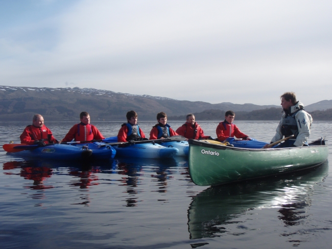 Coaching kayakers from a canoe